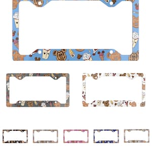 May include: License plate frames with various patterns. One frame has a light blue background with Mickey Mouse-shaped waffles, ice cream cones, and Mickey Mouse heads. Other frames have different patterns and colors.