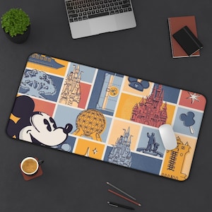 Pode incluir: Um mousepad retangular com uma colagem colorida de ilustrações temáticas da Disney. O design inclui Mickey Mouse, castelos e outras imagens icônicas. O mousepad está em uma superfície escura com um laptop, um caderno e uma xícara de café.
