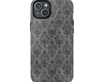 May include: A smartphone case with a gray, textured background featuring a repeating black gothic damask pattern. The case has a camera cutout and black side buttons. The design is reminiscent of vintage wallpaper.