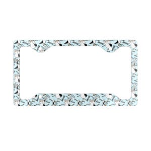 May include: A light blue license plate frame with a repeating pattern of cartoon seagulls and the word "MINE". The frame has a rectangular shape with curved corners and cutouts for mounting.