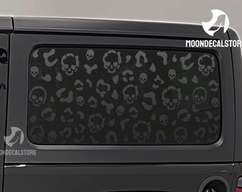 May include: Black Jeep Wrangler with a rear window decal of a skull pattern. The decal is black and white and features a repeating skull design. The decal is on the back window of the Jeep.