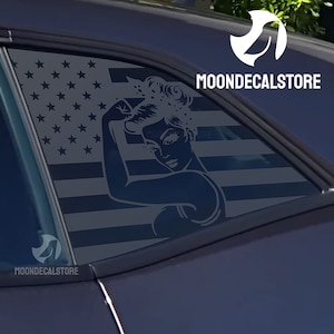 May include: A black car with a rear window decal featuring a woman's silhouette with her arm raised in a 'Rosie the Riveter' pose, superimposed on an American flag design. The decal includes the text "MOONDECALSTORE".