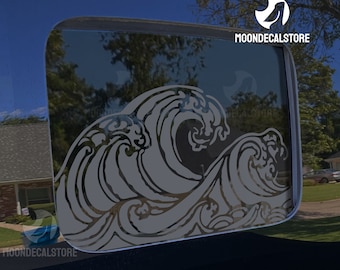 May include: A gray wave design decal for a car window. The decal features a stylized wave pattern with intricate details.