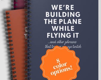 We're Building the Plane While Flying It Notebook - Funny Work Journal for Corporate Jargon, Eye Twitch Humor - Multiple Colors Available