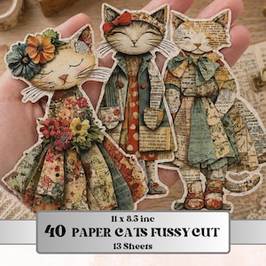 Könnte beinhalten: Drei Papierkatzen-Ausschnitte mit floraler und Vintage-Kleidung. Die Katzen werden in einer Hand gehalten. Der Text unten lautet "40 PAPER CATS FUSSY CUT" und "13 Sheets". Die Papierkatzen messen 27,9 x 21,6 cm.