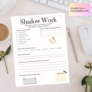May include: A white Shadow Work worksheet with prompts for self-reflection. The worksheet includes sections for identifying avoided behaviors, underlying emotions, and personal growth. A pen, mouse, and keyboard are in the background.