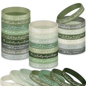 May include: A collection of silicone wristbands in various shades of green and white. Each band features an inspirational quote in white lettering. The bands are stacked in cylindrical arrangements and also displayed individually.