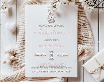 Può includere: Un invito per un baby shower con un'illustrazione di coniglietto e testo rosa. L'invito include il testo "Unisciti a noi per un baby shower in onore di Kaitlyn Smith" e i dettagli dell'evento. L'invito è circondato da fiori e una morbida coperta.