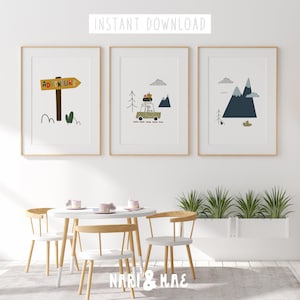 May include: Three framed prints with a white background. The left print features a sign that says "Adventure" with a car driving through a mountain landscape in the middle print. The right print features a mountain range with a blue sky and white clouds.