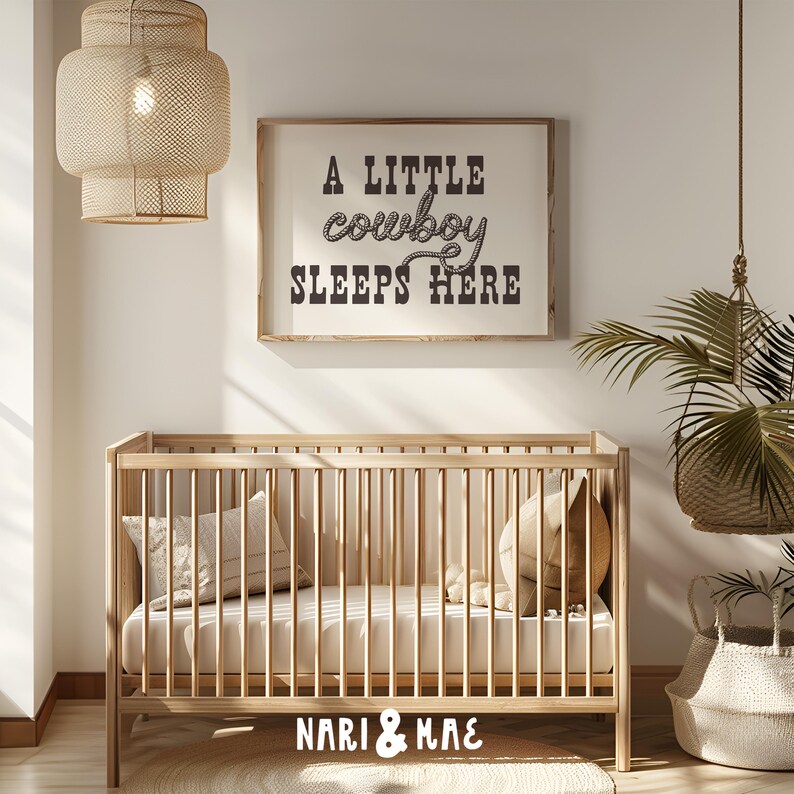 May include: A wooden crib with a white mattress and a sign above it that reads "A little cowboy sleeps here".