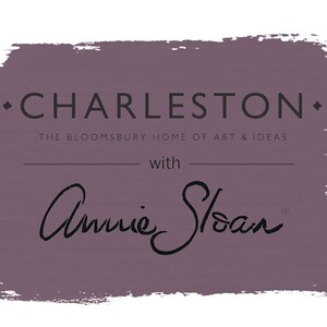 May include: A purple paint colour swatch with the text "Charleston" and "The Bloomsbury Home of Art & Ideas" with "Annie Sloan" written in cursive below.