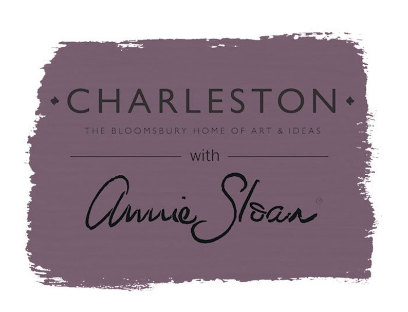 May include: A purple paint colour swatch with the text "Charleston" and "The Bloomsbury Home of Art & Ideas" with "Annie Sloan" written in cursive below.