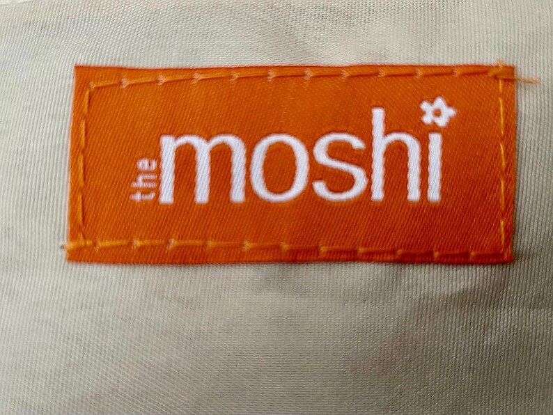 以下が含まれることがあります： オレンジ色のラベルに白い文字で「the moshi」と小さな星マークが書かれています。