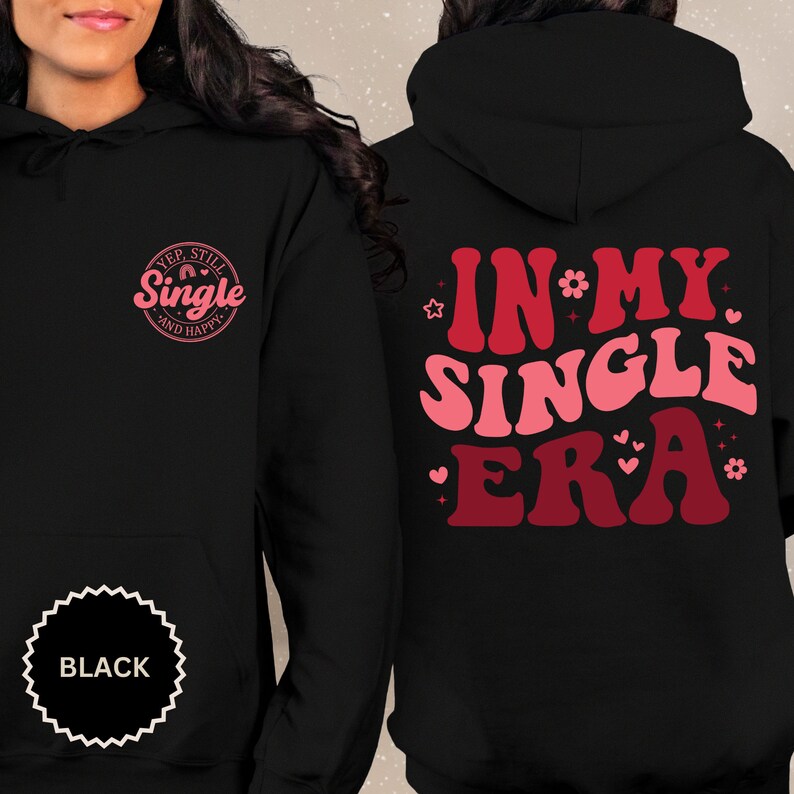 May include: Black hoodie with a pink and red graphic on the back that says "In My Single Era" and a pink graphic on the front that says "Yep, Still Single and Happy".
