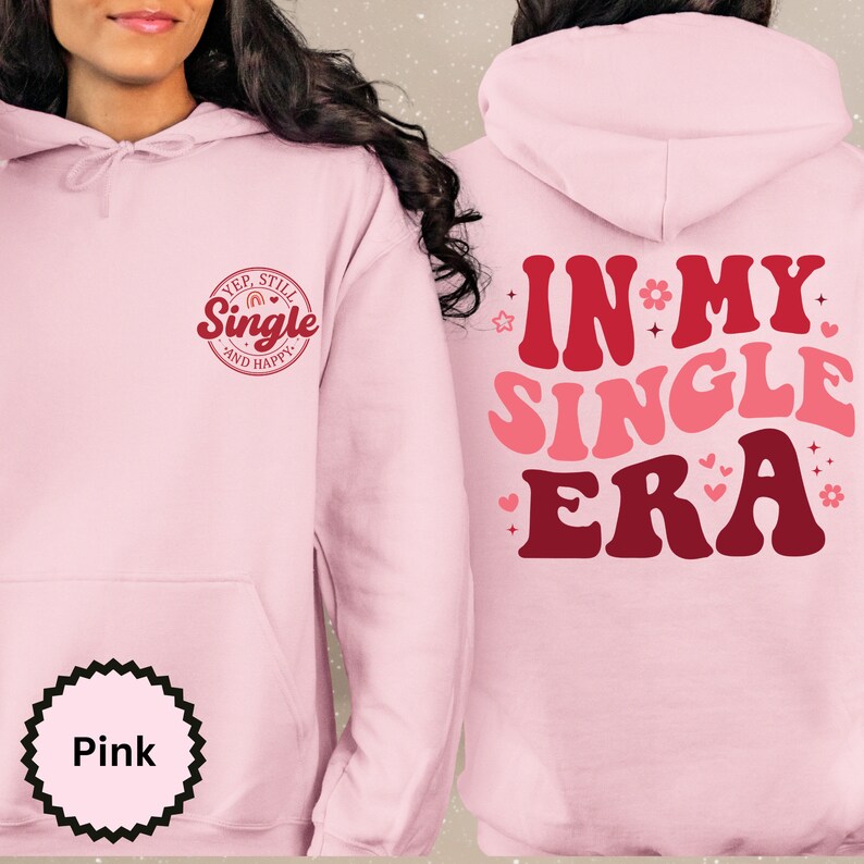 May include: Pink hoodie with the text "Yep, Still Single and Happy" on the front and "In My Single Era" on the back. The text is in a retro font with hearts and stars.