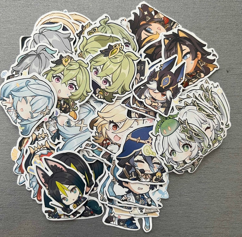 Op de afbeelding: Een verzameling kleurrijke anime-personage stickers met verschillende personages met verschillende uitdrukkingen en poses. De stickers zijn gedrukt op wit papier en hebben een glanzende afwerking.