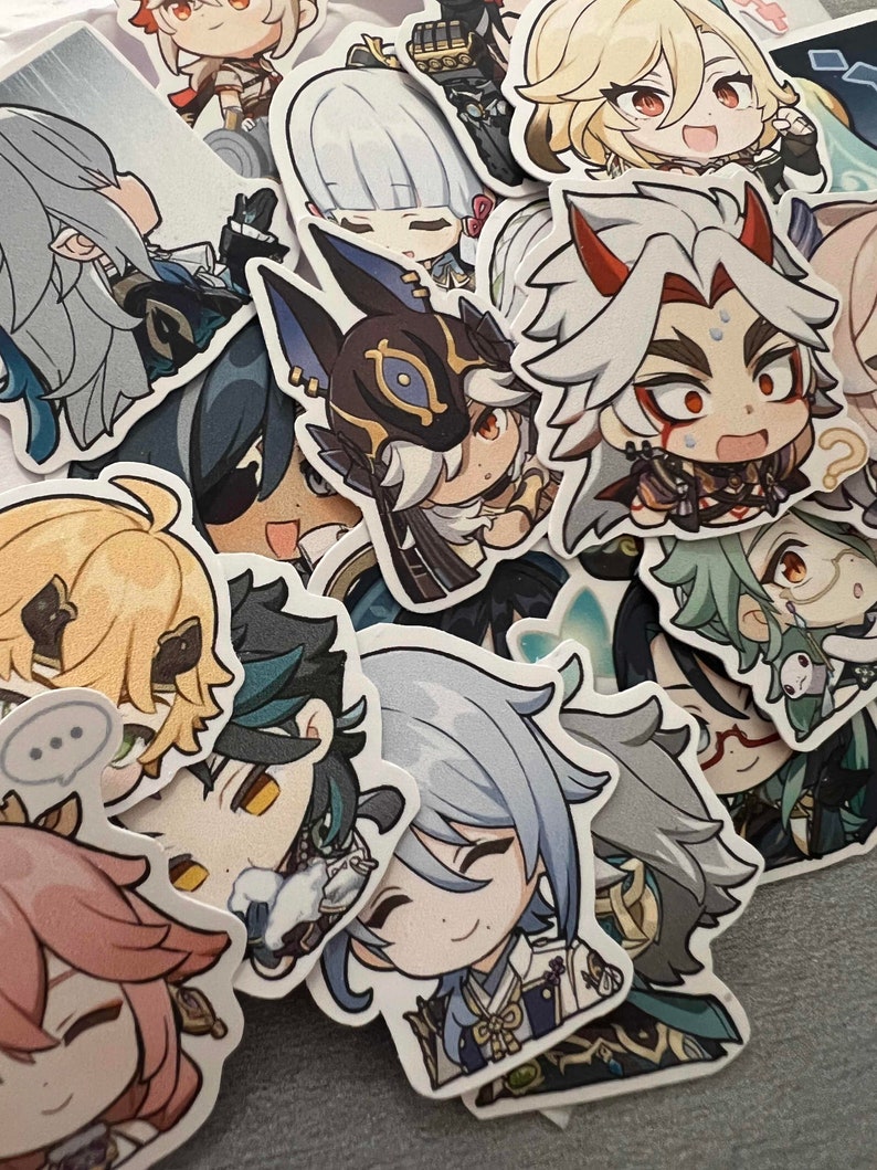 Op de afbeelding: Een verzameling kleurrijke anime-achtige karakterstickers met verschillende karakters in verschillende poses en met verschillende gezichtsuitdrukkingen. De stickers zijn gedrukt op wit papier en hebben een glanzende afwerking.