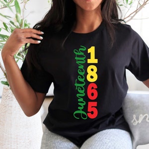 May include: A black t-shirt with the text "Juneteenth 1865" printed vertically in green, yellow, and red.