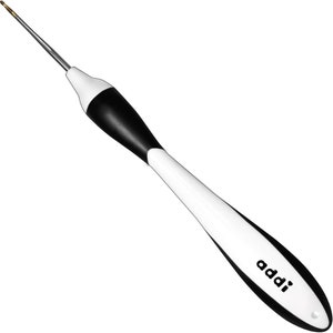 May include: A black and white knitting needle with a gold tip and the word "addi" printed on the handle.