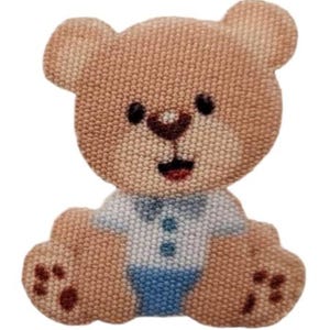 Puede incluir: Aplicación de oso de peluche marrón con camisa azul claro y pantalones cortos azules. El oso tiene ojos negros, nariz marrón y boca roja. La aplicación está hecha de tela texturizada.