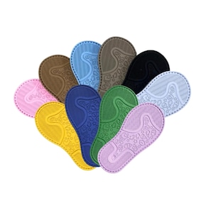 Puede incluir: Una colección de plantillas coloridas y estampadas en varios tonos, incluyendo rosa, amarillo, azul y verde. Cada plantilla presenta un diseño texturizado con pequeñas formas y una forma curva, adecuada para zapatos.