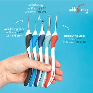 May include: Five addiSwing crochet hooks in different sizes and colors. The hooks are held in a hand. The hooks are labeled with their sizes in millimeters and inches. The hooks are labeled addiSwing Mini and addiSwing Maxi.