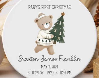 May include: White round ornament with a brown bear holding a green Christmas tree. The ornament says "BABY'S FIRST CHRISTMAS" and includes the name "Braxton James Franklin", the date "MAY 2, 2024", and the time "8 LB 2.4 OZ 19.20 IN 11:34 PM".