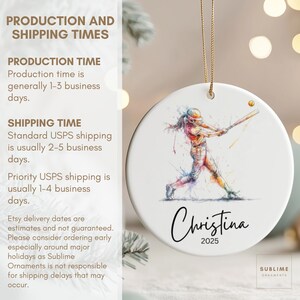 May include: White ceramic ornament featuring a watercolor illustration of a softball player swinging a bat. The ornament includes the name "Christina" and the year "2025" in black script. A gold string is attached for hanging.