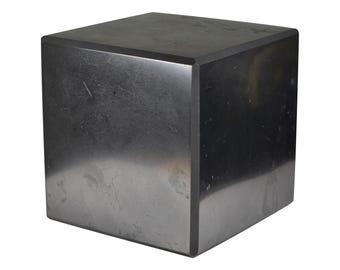 May include: A black cube-shaped pedestal made of a smooth, polished stone. The surface has a subtle sheen and a few faint markings.