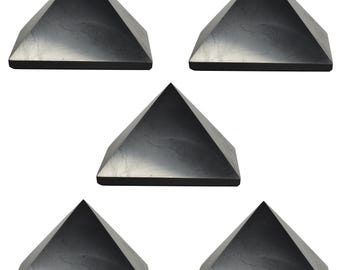 May include: Set of five black obsidian pyramids. Each pyramid is smooth and polished with a slightly reflective surface.