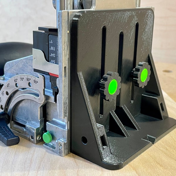 May include: A black and silver woodworking tool with a black base and green accents. The tool has adjustable settings and a gauge for precise measurements. The image shows a close-up of the tool, highlighting its design and features.