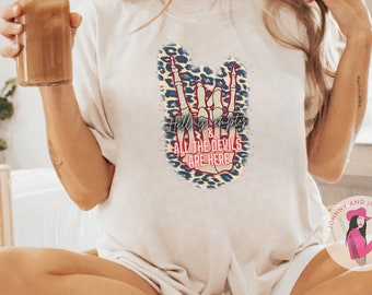May include: Cream-colored t-shirt with a graphic featuring a hand gesture and the text "Hell is Empty & All the Devils Are Here." The design includes leopard print accents in blue, tan, and red. The shirt is paired with white socks with black stripes.