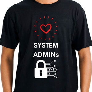 Könnte beinhalten: Schwarzes T-Shirt mit einem weißen Grafikdesign. Die Grafik zeigt ein rotes Herz mit weißem Umriss, umgeben von weißen Punkten. Der Text "SYSTEM ADMINS" befindet sich unter dem Herzen. Unter dem Text befindet sich ein weißes Schloss mit einem Schlüsselloch und einem Schaltkreisdesign.