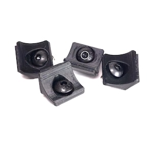 May include: Four black plastic corner protectors with a small round hole in the center of each. The protectors are designed to protect corners from damage.