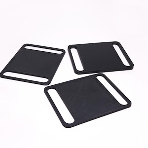 May include: Three black plastic belt loops, each with a rectangular shape and two cut-out openings.