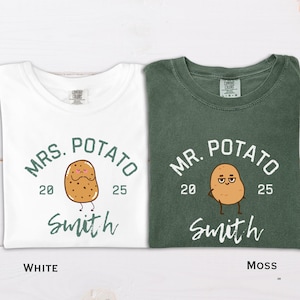 以下が含まれることがあります： ジャガイモのグラフィックが入った2枚のTシャツ。1枚は白で「Mrs. Potato」と2025年、名前「Smith」と書かれています。もう1枚はモスグリーンで「Mr. Potato」と2025年、名前「Smith」と書かれています。
