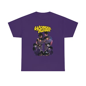 May include: Purple t-shirt with a graphic of four cartoon characters. The characters are wearing purple and black outfits. The text "Wonder Twins" is in yellow above the characters.