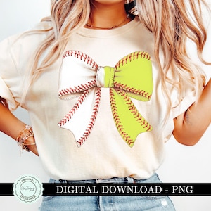 May include: A cream-coloured t-shirt with a baseball and softball bow design. The bow is split, with one side resembling a baseball and the other a softball. The text "DIGITAL DOWNLOAD - PNG" is displayed below the bow.