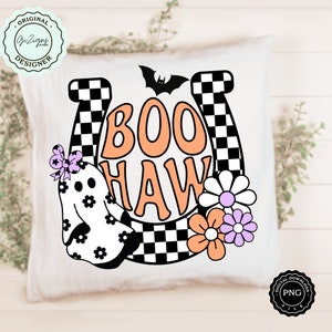 May include: White square pillow with a Halloween-themed design. The design features the words "BOO HAW" in orange and white, a ghost, flowers, a bat, and a horseshoe with a checkered pattern. The pillow has a "Original Designer" logo.