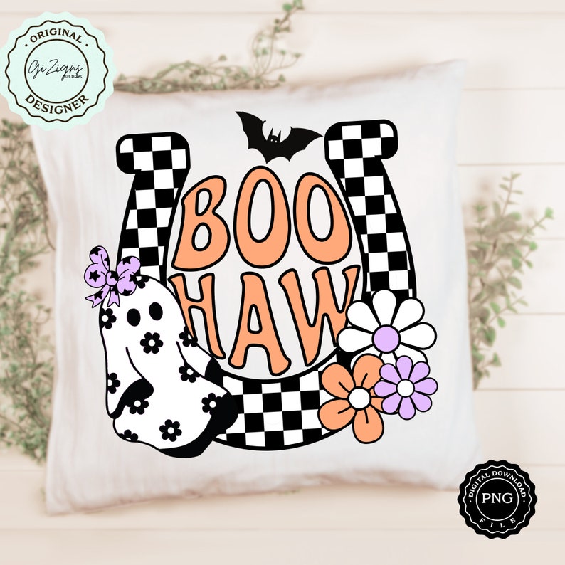 May include: White square pillow with a Halloween-themed design. The design features the words "BOO HAW" in orange and white, a ghost, flowers, a bat, and a horseshoe with a checkered pattern. The pillow has a "Original Designer" logo.