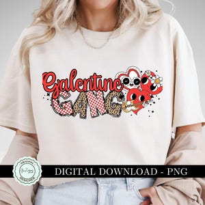 May include: A white t-shirt with the text "Galentine Gang" in red and black letters. The text is surrounded by hearts, flowers, and a guitar. The shirt is a digital download and comes in PNG format.