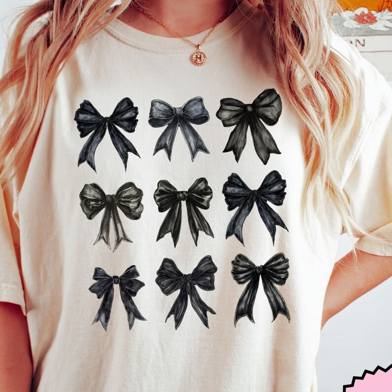 May include: A white t-shirt with a black and white design of nine different bow shapes.