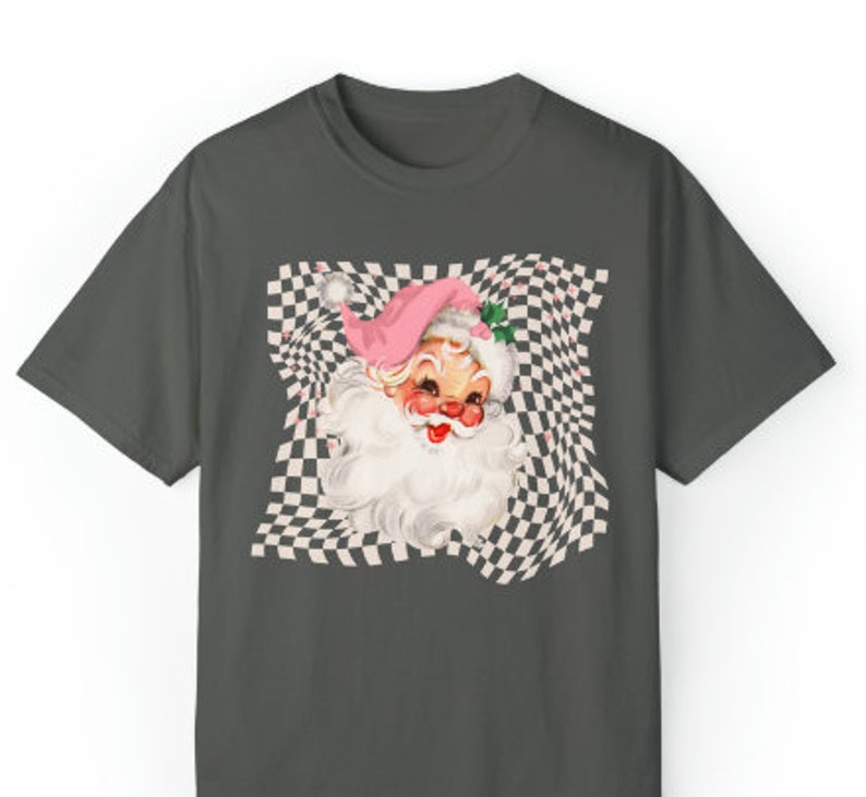 May include: A dark gray t-shirt with a vintage illustration of Santa Claus's face on a checkered background. The checkered pattern is distorted, creating a swirling effect.