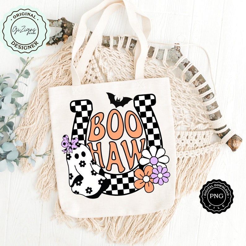 May include: Cream-colored tote bag with the words "BOO HAW" in orange and white, featuring a ghost, flowers, and a horseshoe design. The bag has a black and white checkered pattern and a bat graphic. The bag has cream-colored handles.