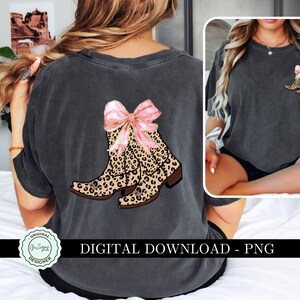 K&ouml;nnte beinhalten: Ein digitaler Download eines Grafikdesigns mit einem Paar brauner Cowboystiefel mit einer rosa Schleife. Die Stiefel haben ein Leopardenmuster.