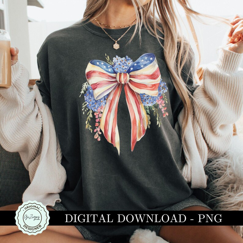 May include: A dark gray t-shirt with a watercolor design of an American flag bow with red, white, and blue stripes and a floral wreath. The text "DIGITAL DOWNLOAD - PNG" is at the bottom of the image.