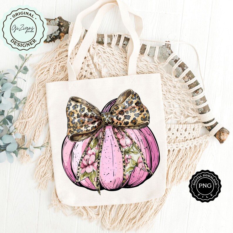 Pode incluir: Uma ab&oacute;bora rosa com um design floral e um la&ccedil;o de estampa de leopardo. A ab&oacute;bora est&aacute; em uma bolsa de tecido branca.
