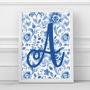 May include: A framed print featuring a blue floral pattern and a large, stylized letter "A" in a matching blue hue. The artwork has a watercolor effect, with a white background and a white frame.