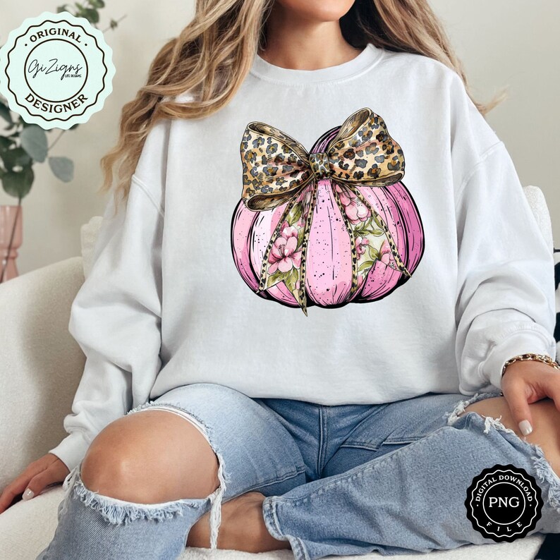 Pode incluir: Uma ab&oacute;bora rosa com um design floral e um la&ccedil;o de estampa de leopardo. A ab&oacute;bora est&aacute; sobre um fundo branco.
