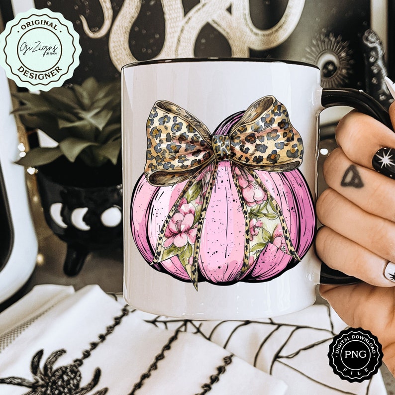 Pode incluir: Caneca de cer&acirc;mica branca com uma ab&oacute;bora rosa com um la&ccedil;o de estampa de leopardo e detalhes florais. A caneca tem uma borda e uma al&ccedil;a pretas.